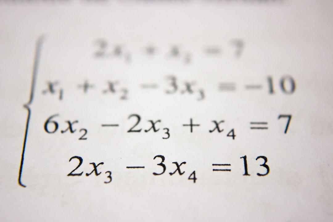 Un élève concentré sur ses exercices de maths, installé à une table de la bibliothèque du lycée.