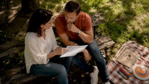 Des parents assis autour de la table de la cuisine, en train de parcourir le bulletin scolaire de leur enfant.