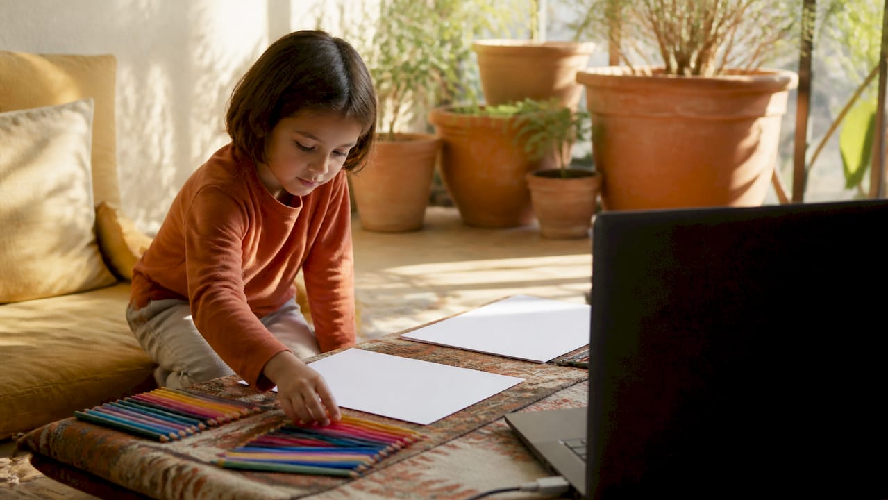 Child preparing laptop for online tutoring