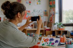 Enseignant prenant en photo une œuvre d'art d'enfant en maternelle