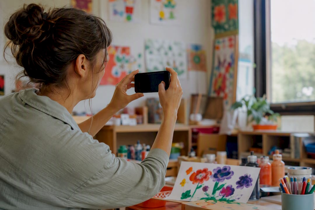 Enseignant prenant en photo une œuvre d'art d'enfant en maternelle
